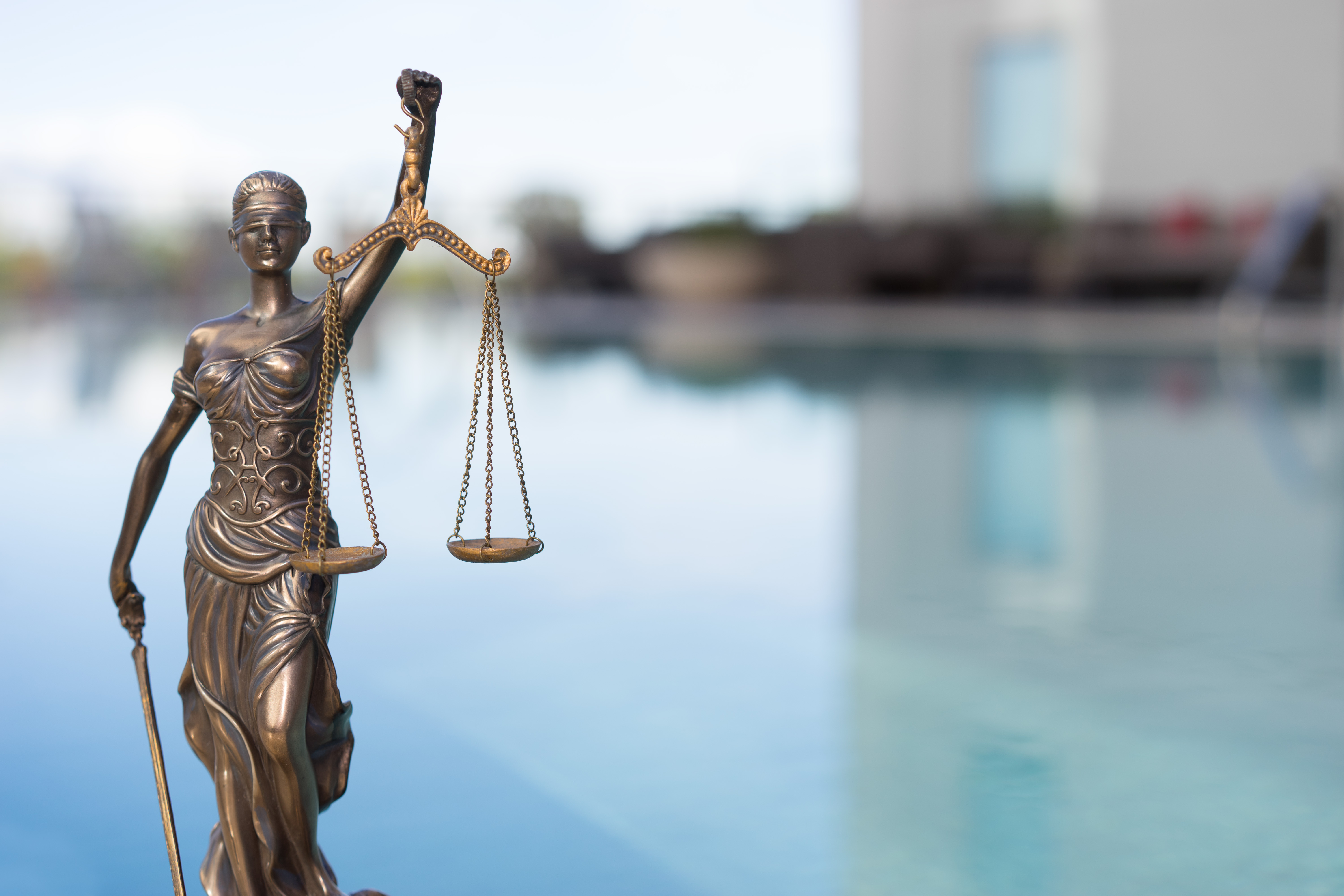Photo d'une statue représentant la justice devant un fleuve
