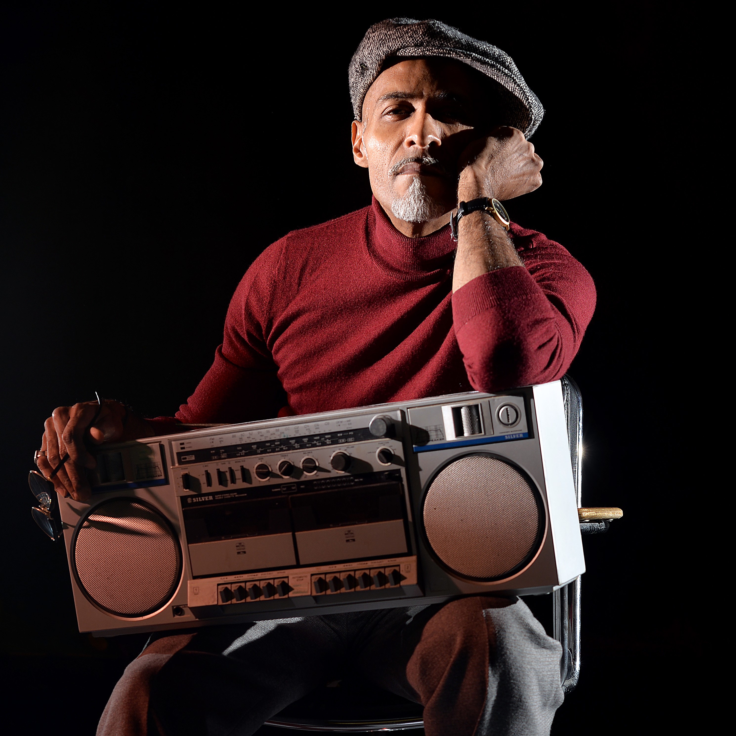 Portrait de Fred Bendongué assis avec une radio sur les genoux