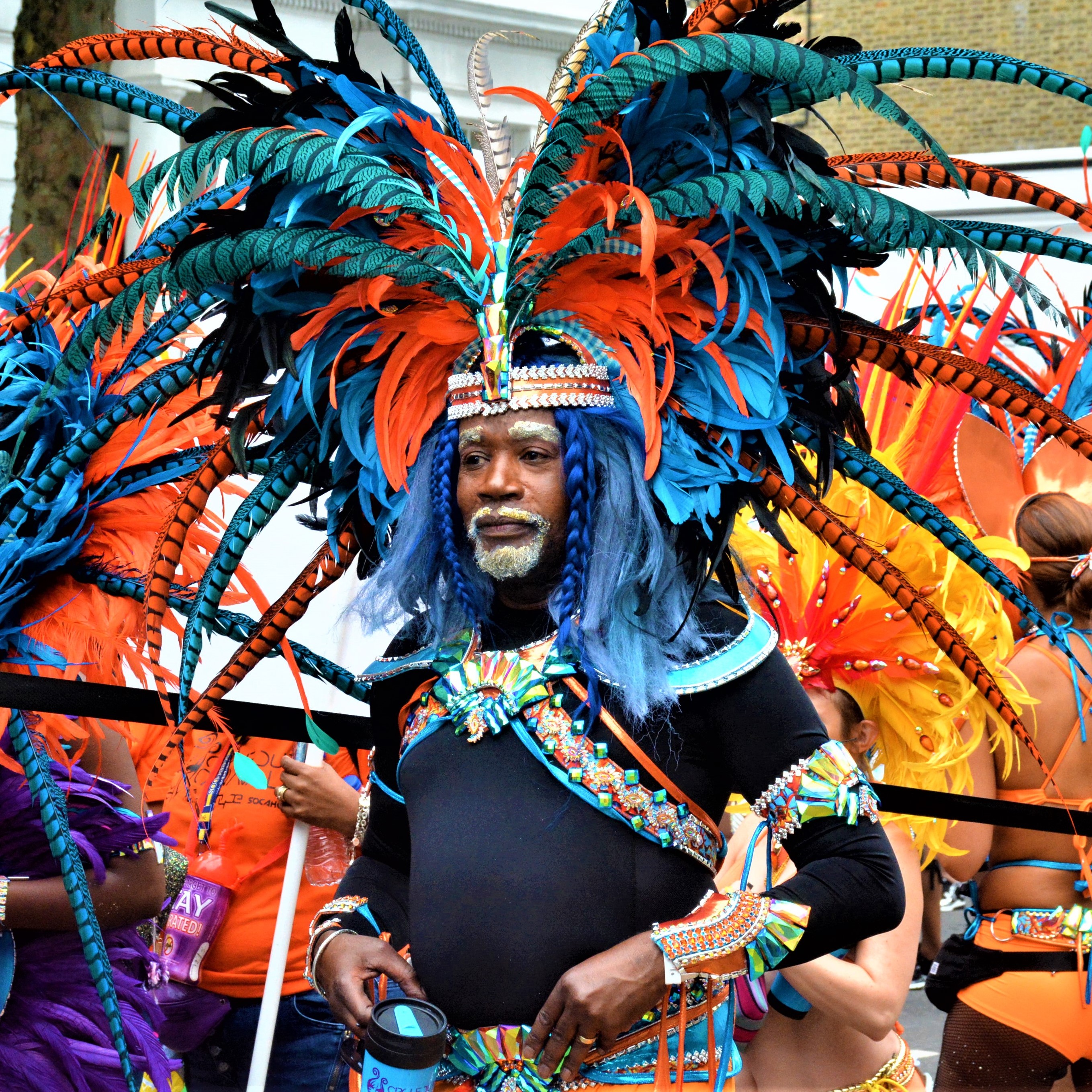 Photo d'un homme en tenue de carnaval très colorée avec une coiffe en plumes