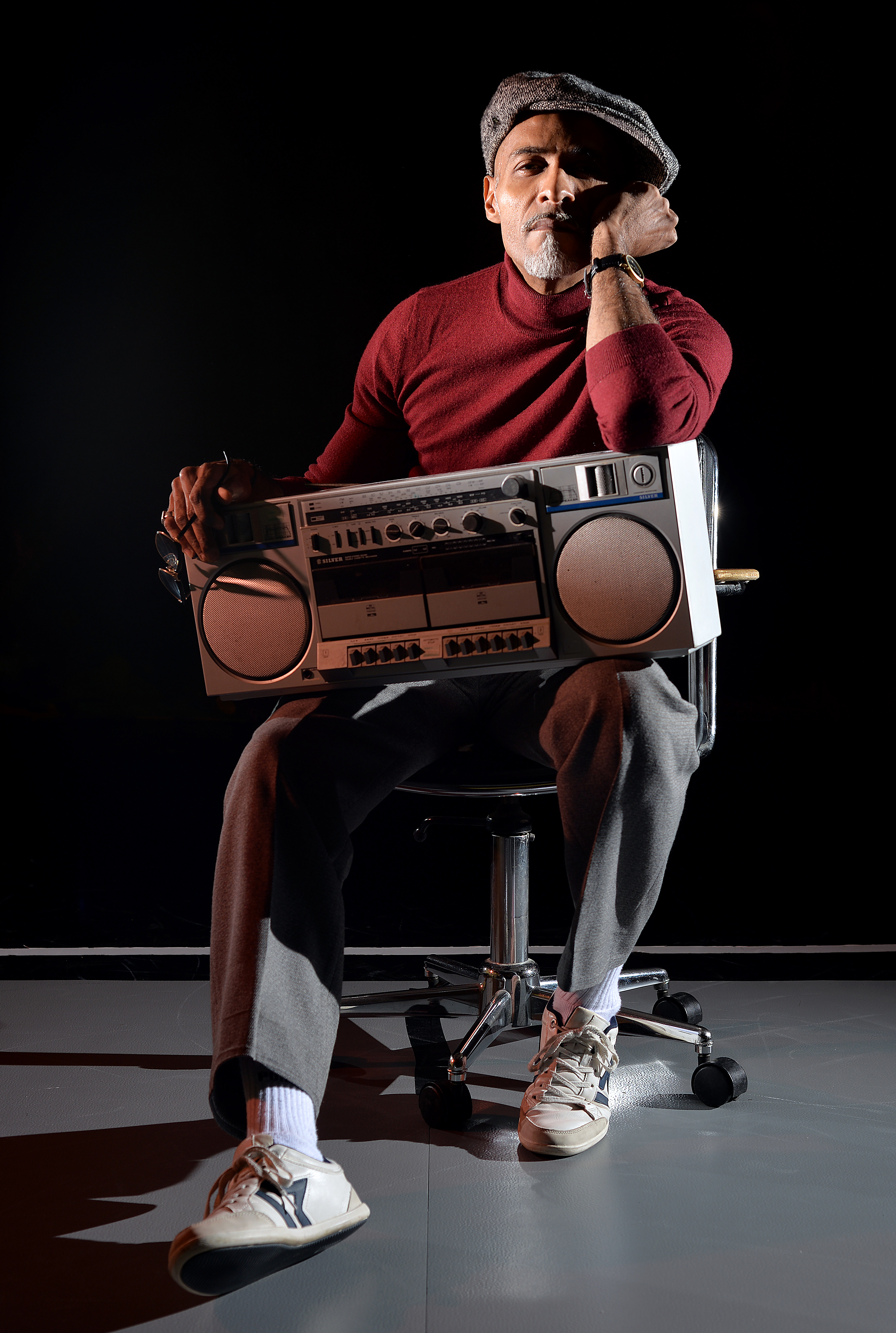 Portrait de Fred Bendongué assis avec une radio sur les genoux