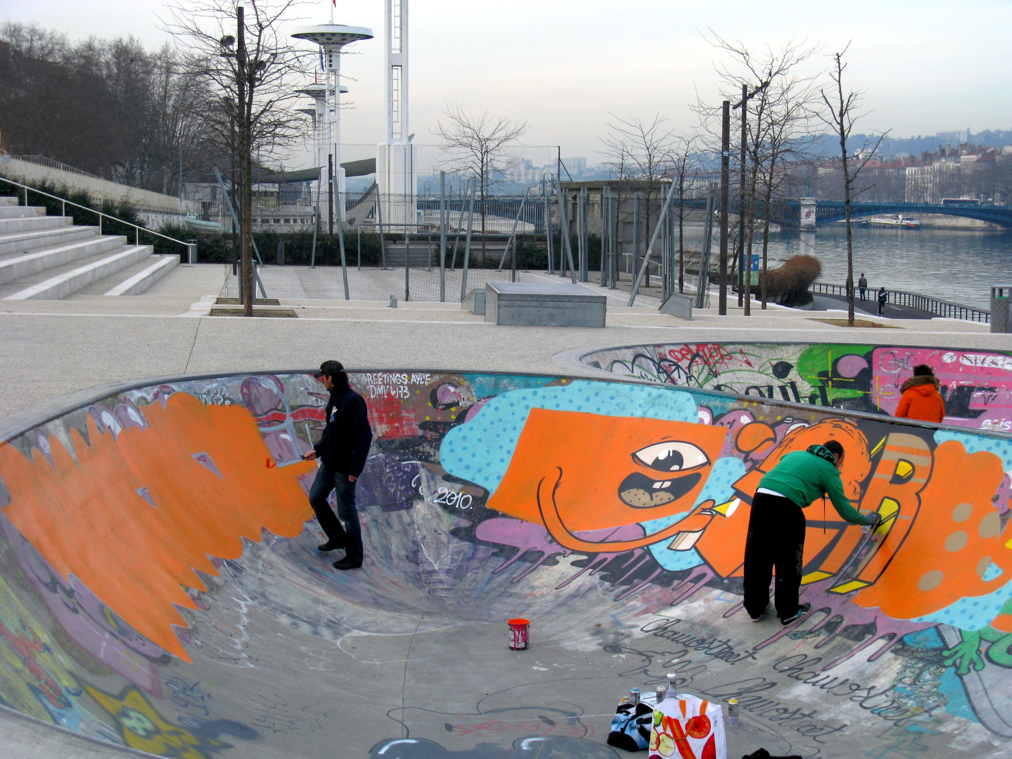 Photo de deux graffeurs en train de dessiner dans le bowl de skate du quartier de la Guillotière
