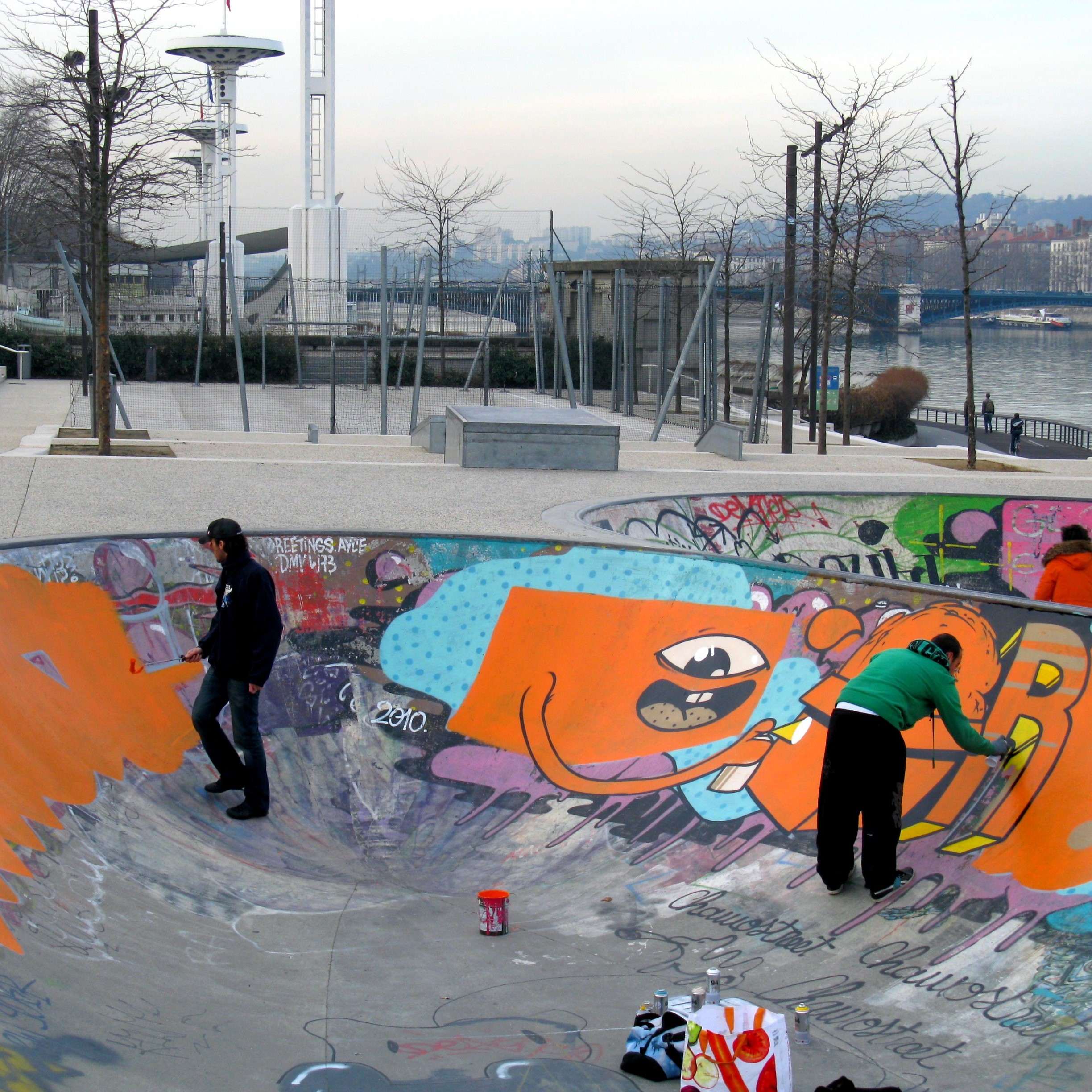 Photo de deux graffeurs en train de dessiner dans le bowl de skate du quartier de la Guillotière