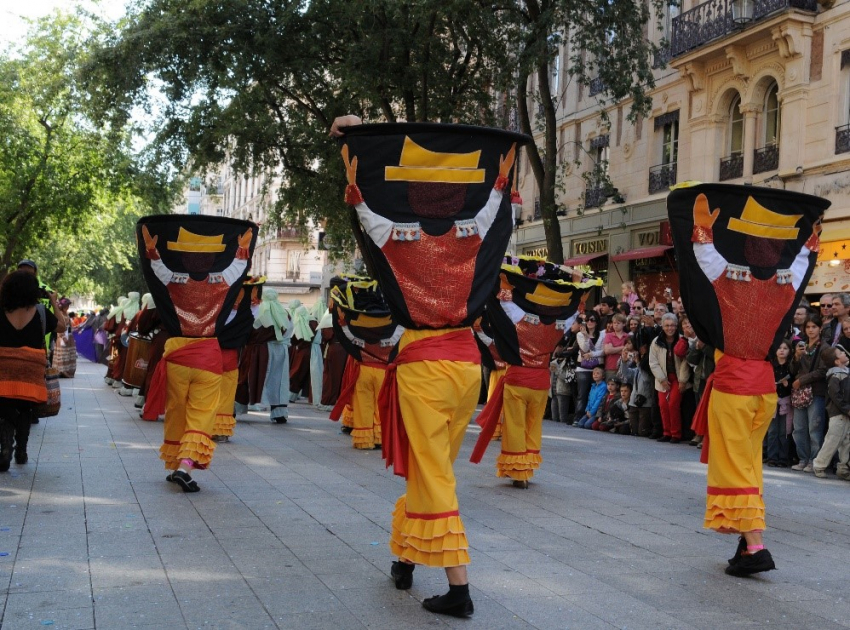 Photo d'un groupe de personnes marchant avec des tenues traditionnelles espagnoles le long de la rue de la République à Lyon