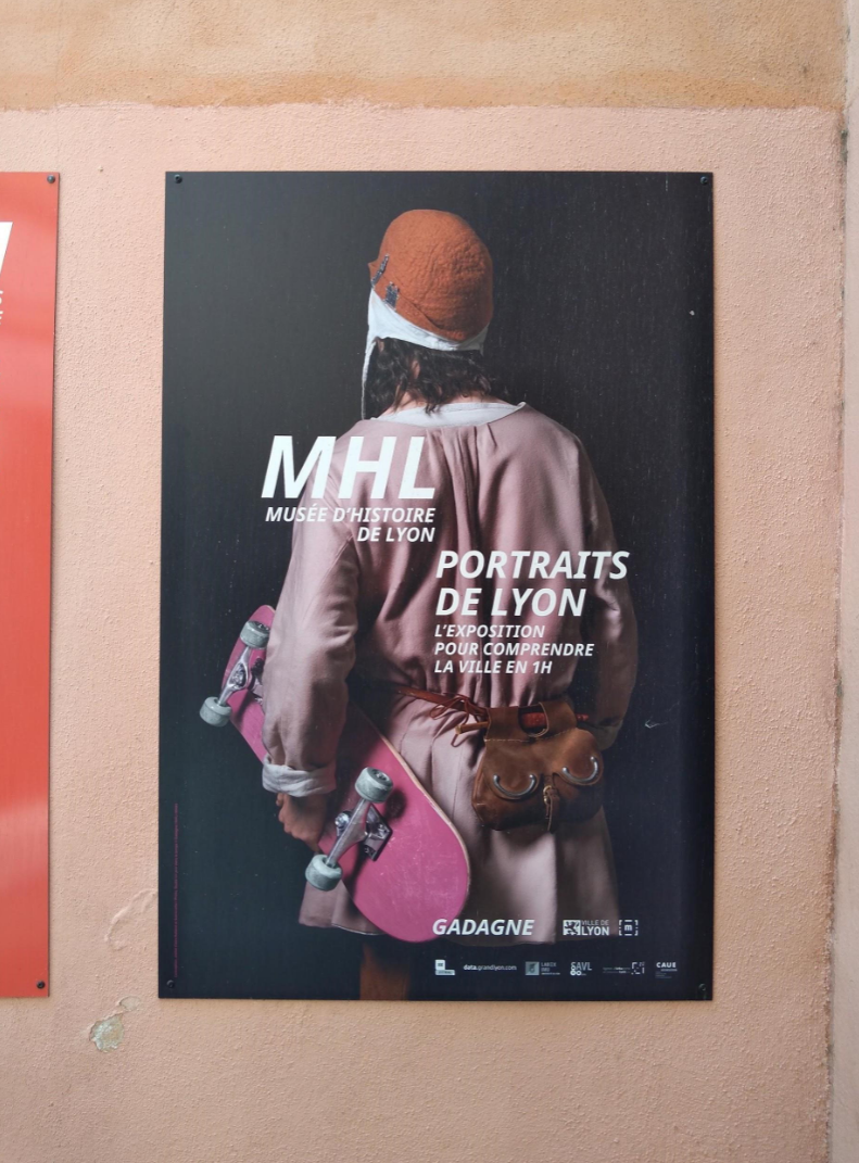 Photo de l'affiche de l'exposition Portraits de Lyon du Musée Gadagne, un skateur habillé en vêtements baroque roses qui tient son skate rose dans sa main